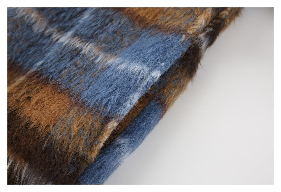 Close-up of the fuzzy blue and brown plaid fabric and finished edge of the jacket.