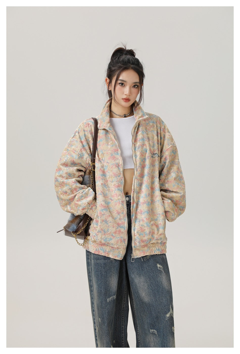 Model wearing an open pastel multicolor zip-up jacket with a high collar and oversized sleeves.