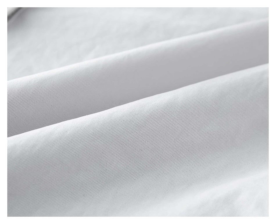 Extreme close-up of the fine diagonal weave in white trouser fabric.