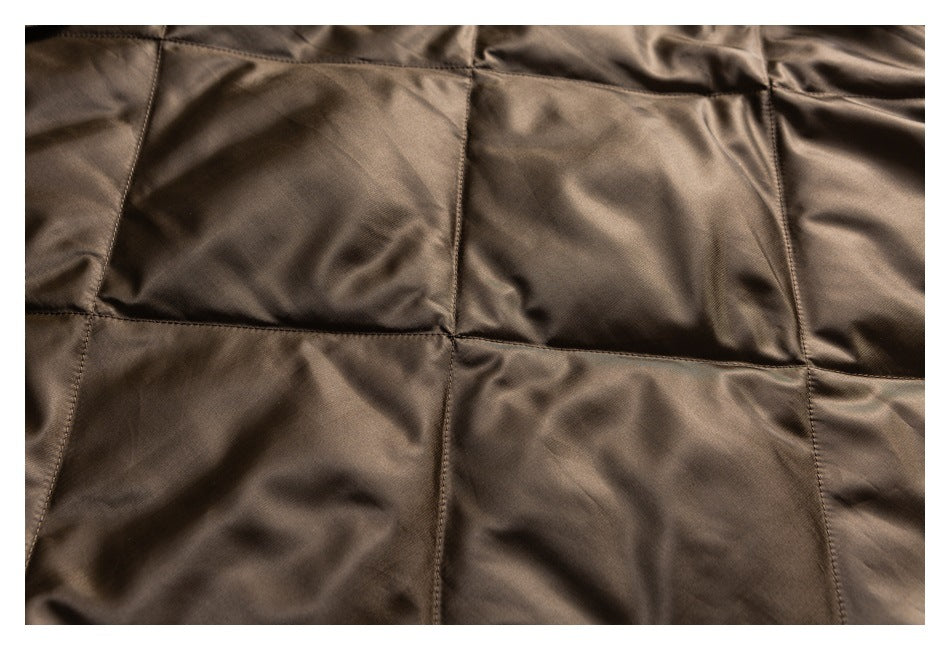 Close-up of dark brown garment fabric with large rectangular stitched panels.