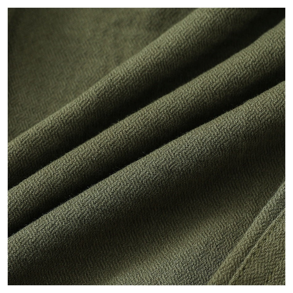 Macro view of olive-green fabric folded to show its fine woven texture.