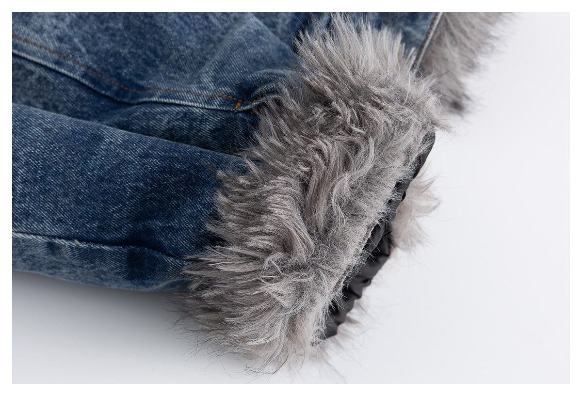 Close-up of fluffy gray trim along the edge of a faded blue denim jacket.