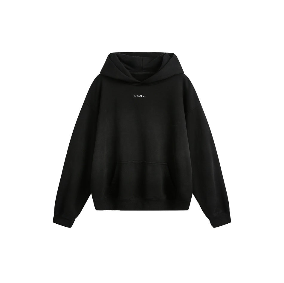 Washed black pullover hoodie flat lay with kangaroo pocket, ribbed cuffs and small white 'breathe' text on chest