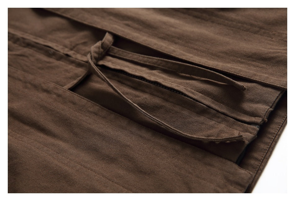 Close-up of a brown garment opening with a drawstring and stitched edges.