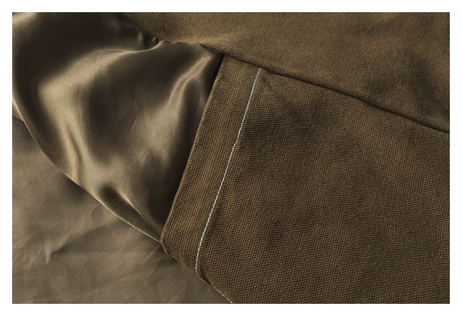 Close-up of olive-brown garment fabric, showing a stitched seam beside a smooth inner lining.