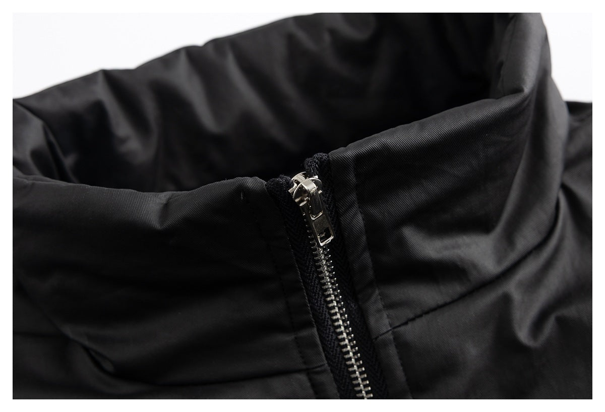 Close-up of black garment fabric with a shiny silver zipper and stitched seams.