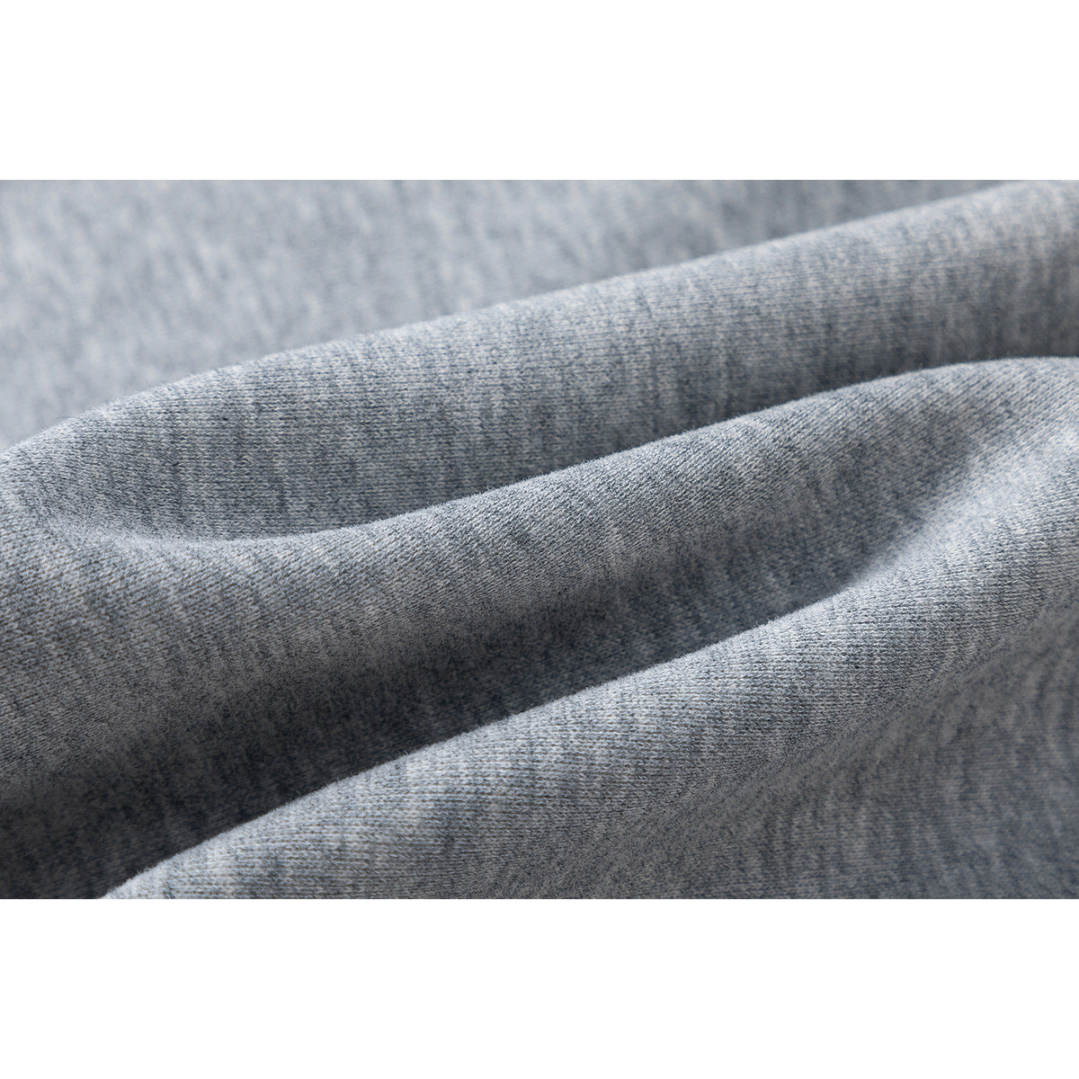 Macro view of the heather-gray sweatshirt fabric folded to show its surface texture.