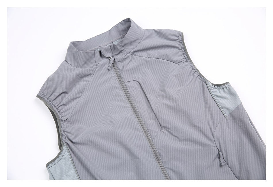 Angled close view of a gray sleeveless vest front, showing the high collar, zipper, and pale side panels.