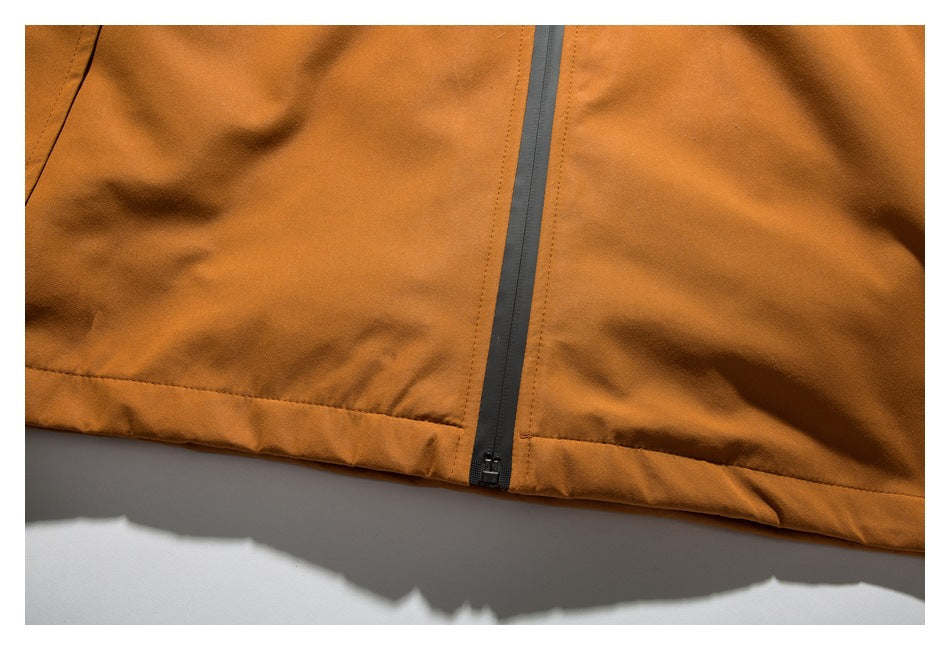 Close-up of the orange jacket's lower front, showing the central zipper and stitched hem.