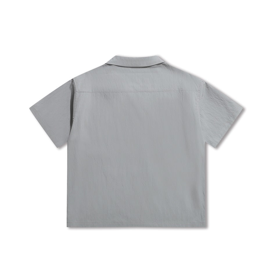 Ice blue short-sleeve shirt, flat lay back view showing yoke seam and crinkled fabric