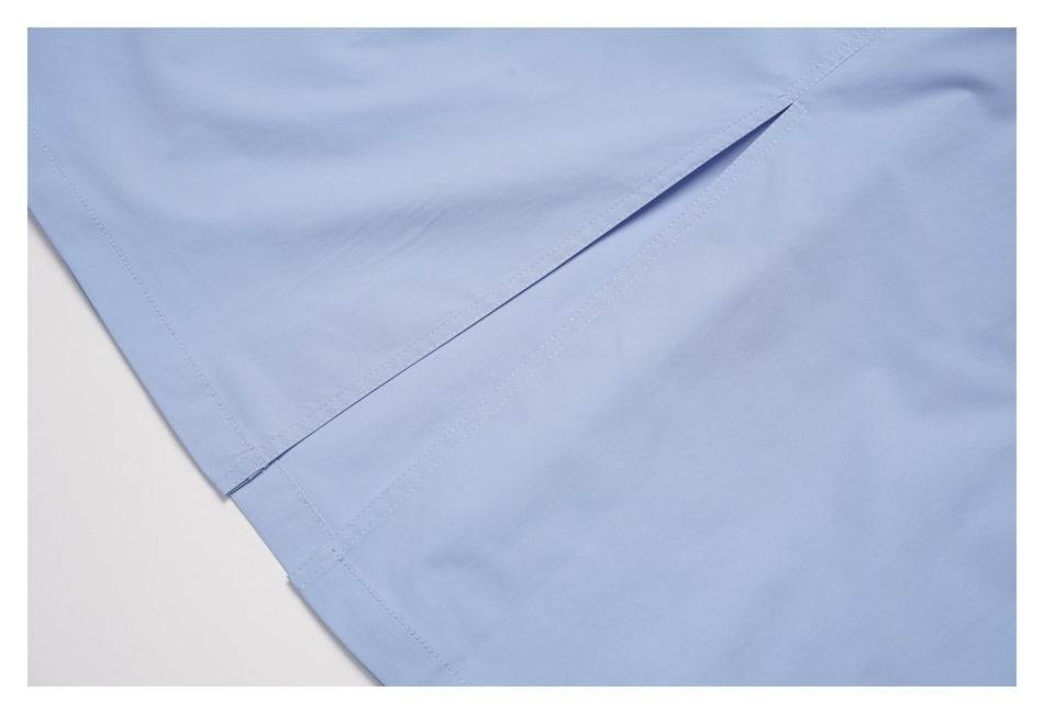 Close-up of a narrow slit opening between overlapping panels of light blue fabric, with stitched edges.