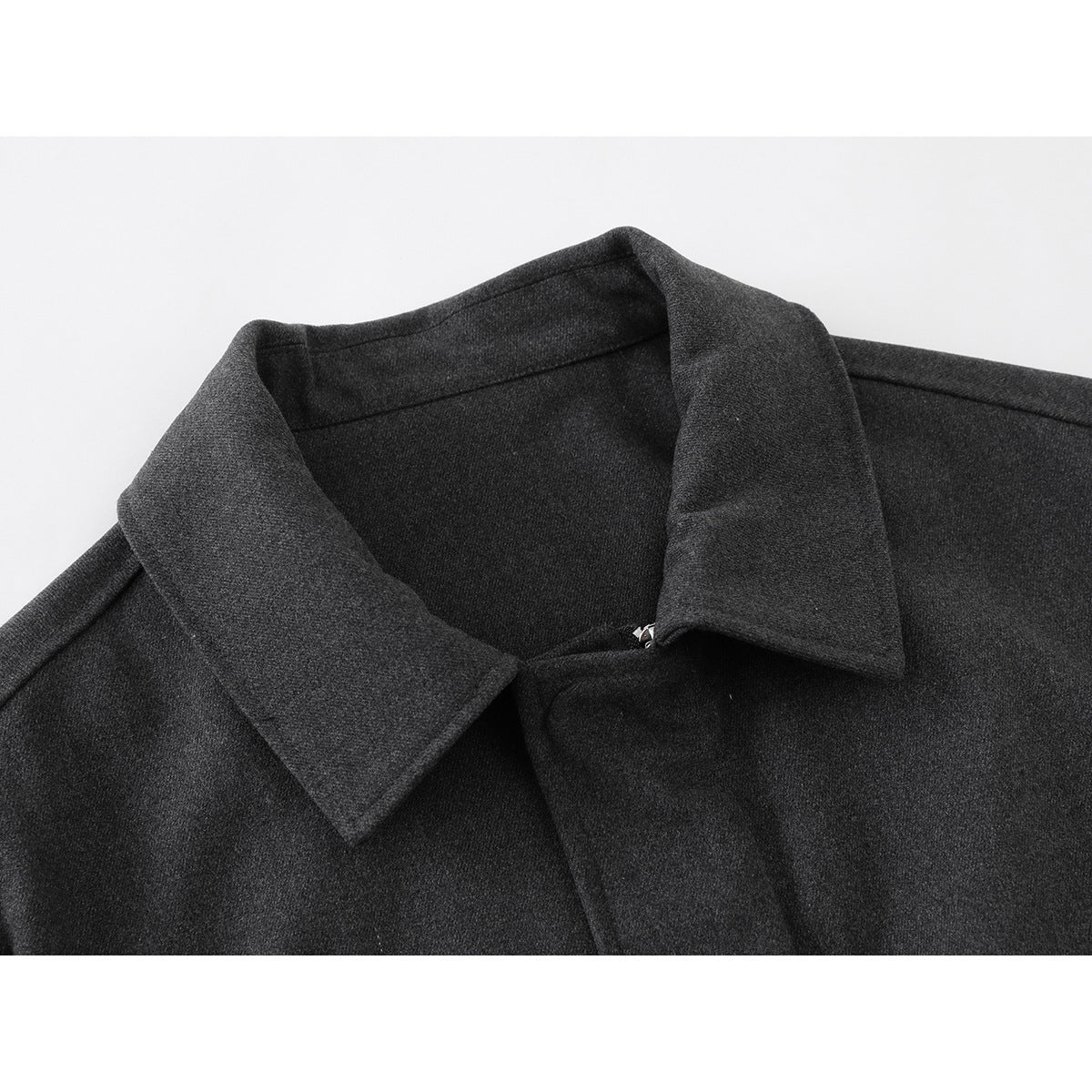 Close-up of a dark charcoal jacket's wide pointed collar and front fastening.