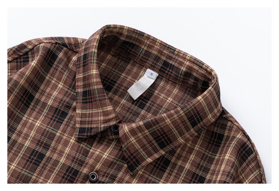 Close-up of the brown plaid shirt collar, top buttons, and inner neck label.