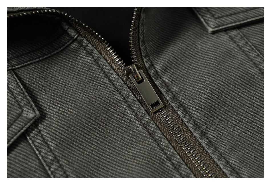 Close-up of the metal zipper and textured charcoal gray fabric on a jacket front.
