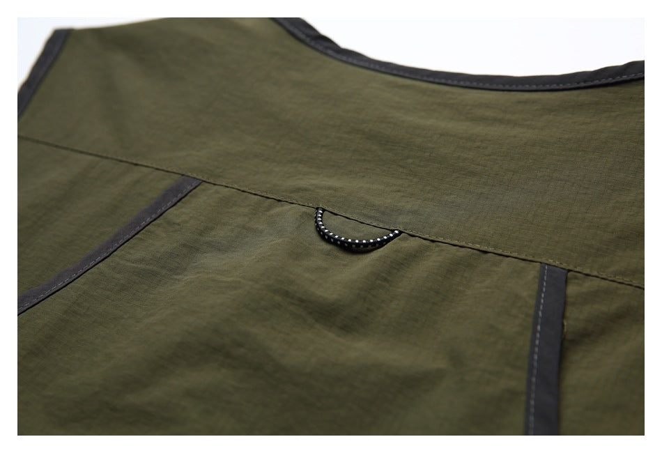 Close-up of the olive-green garment's back panel, dark edging, and small loop.