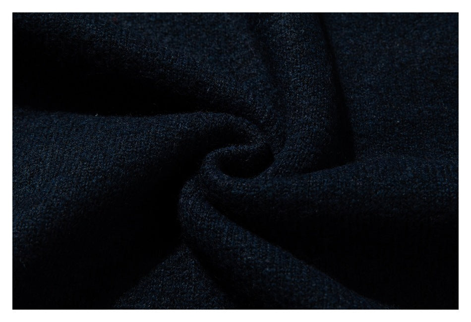 Close-up of the dark navy sweater’s knit surface draped into folds.