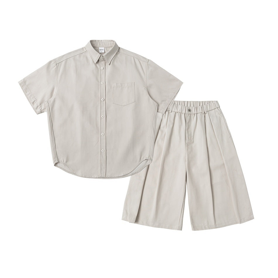 Flat lay of a light beige short-sleeve button-up shirt with a chest pocket and matching wide-leg shorts.