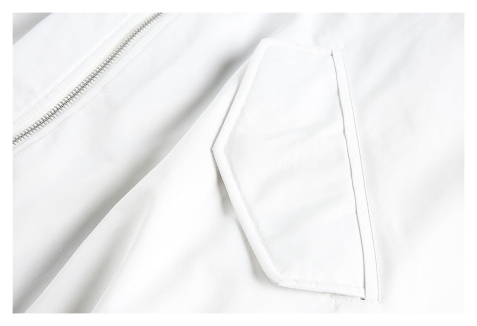 Close-up of a white jacket's flap pocket beside the front zipper.