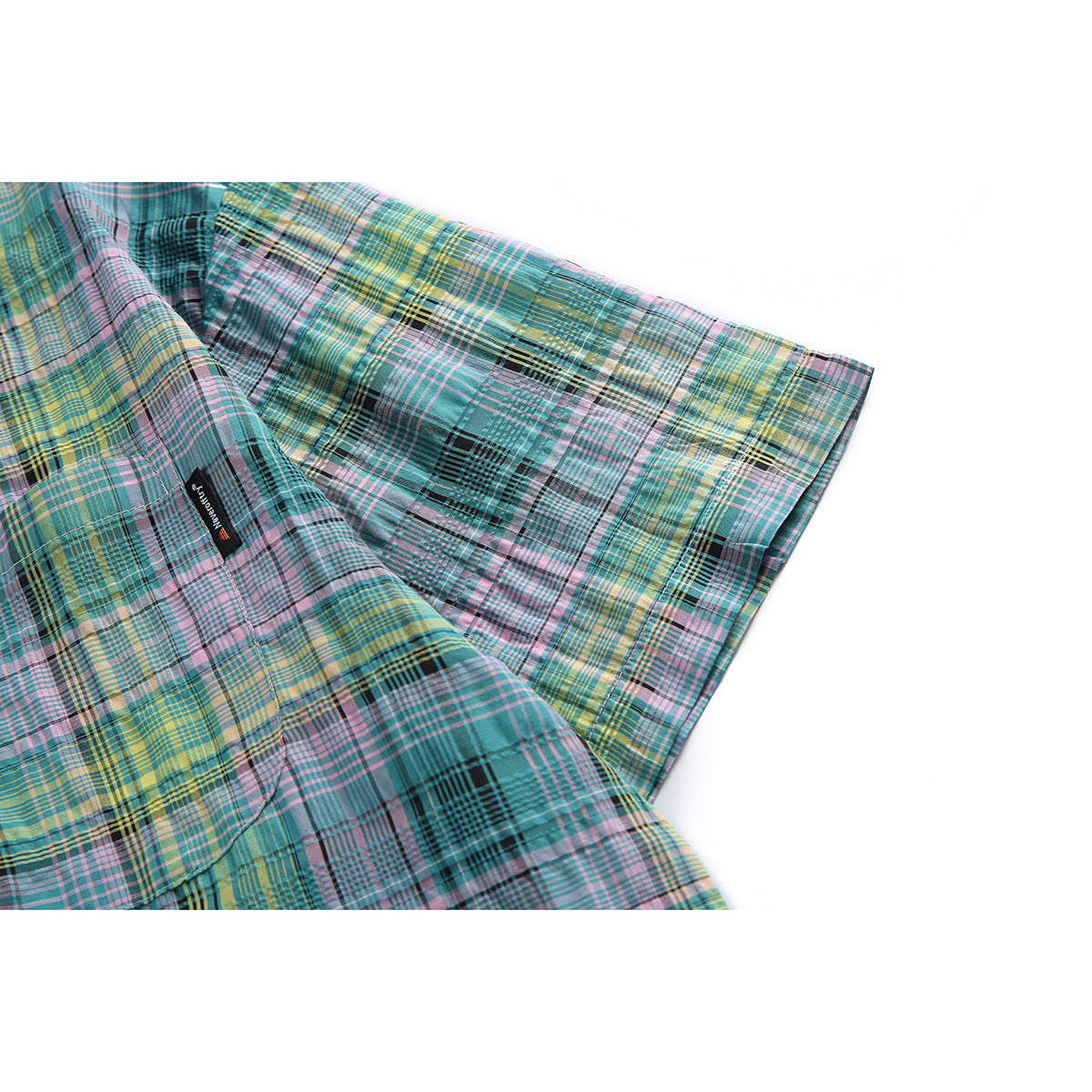 Close-up of the shirt's short sleeve and multicolor plaid pattern, with a small sewn label.