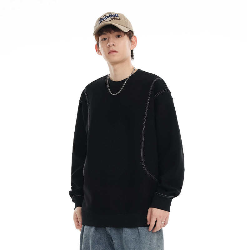 Model wearing a black crewneck sweatshirt with contrast stitching, ribbed cuffs and hem, and curved front seams.