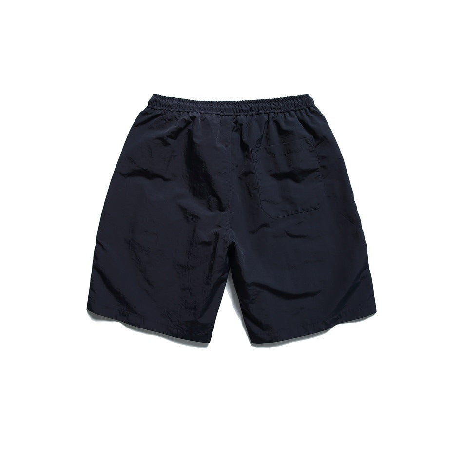 Navy shorts back view with elastic waistband and a patch pocket on the right back, flat lay