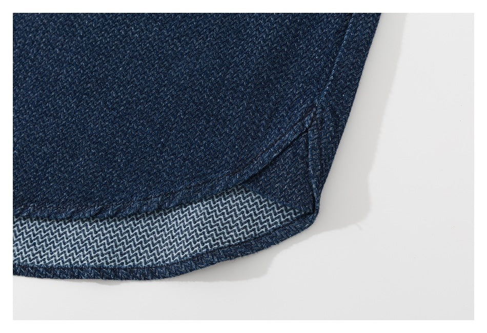 Close-up of the curved hem of a dark navy patterned shirt, showing the contrasting underside.