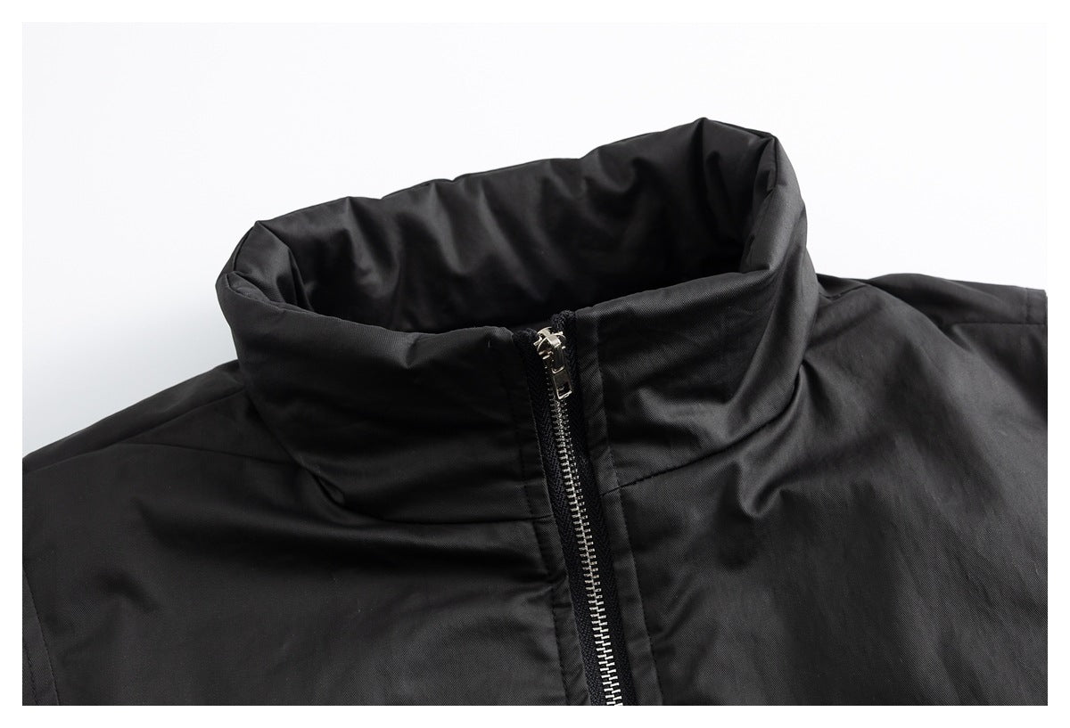 Close-up of a black jacket's high stand collar and silver front zipper.