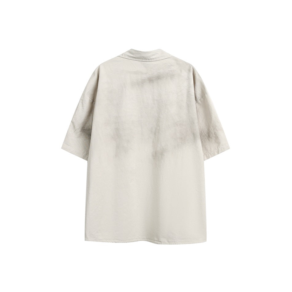 Back view of a light beige short-sleeve shirt with a collar and relaxed, straight hem.