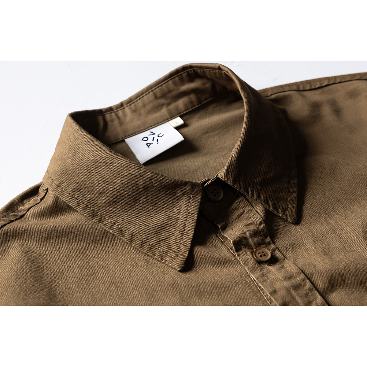 Close-up of a brown button-up shirt collar, placket, and neck label.