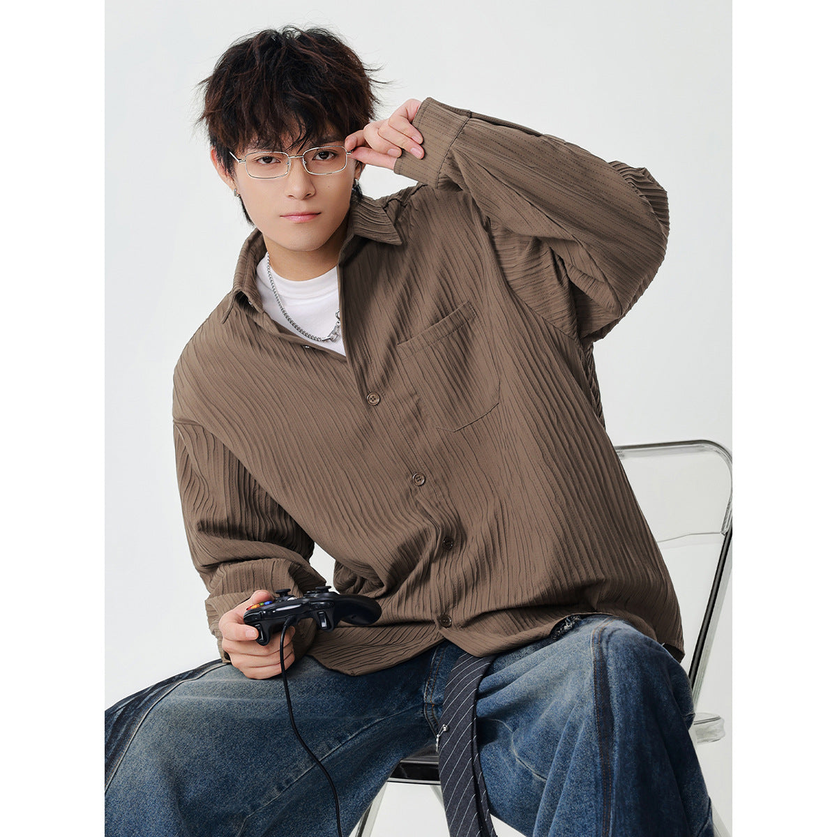Seated model wearing a taupe-brown textured button-up overshirt with a chest pocket.