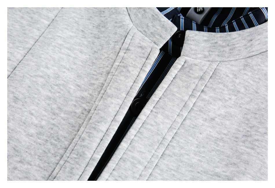 Close-up of the light gray garment's collar and black-button placket, with navy striped lining visible inside the neckline.