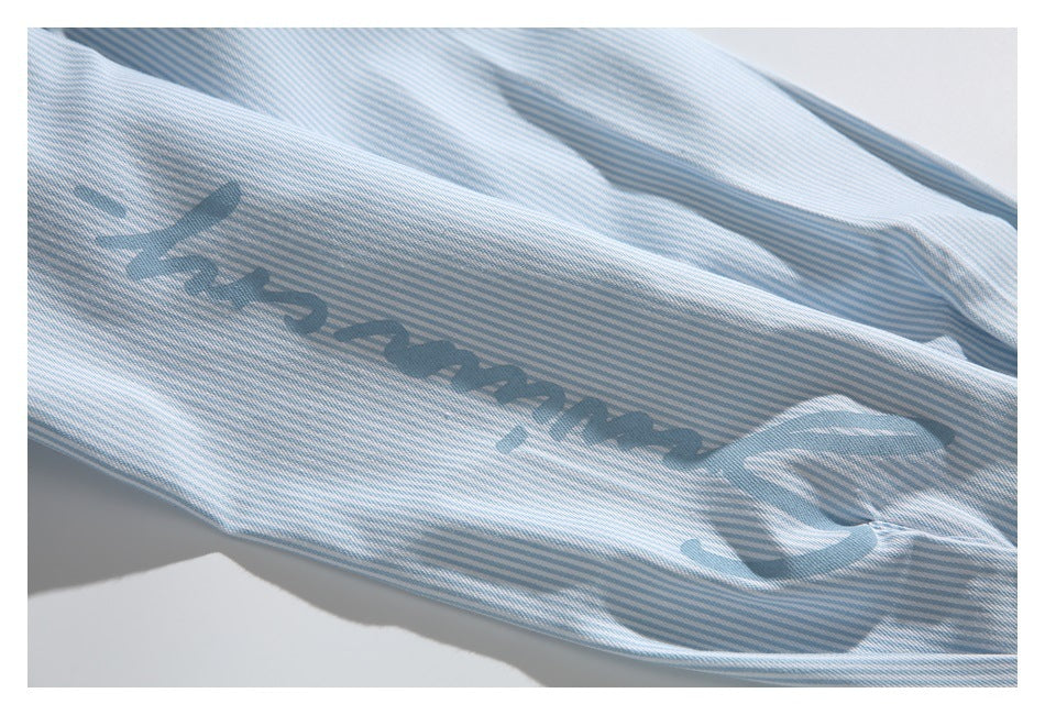 Close-up of dark blue lettering printed on a light blue and white striped shirt.