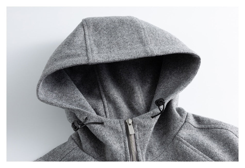 Close-up of a gray jacket's hood, drawcord toggles, and central zipper.