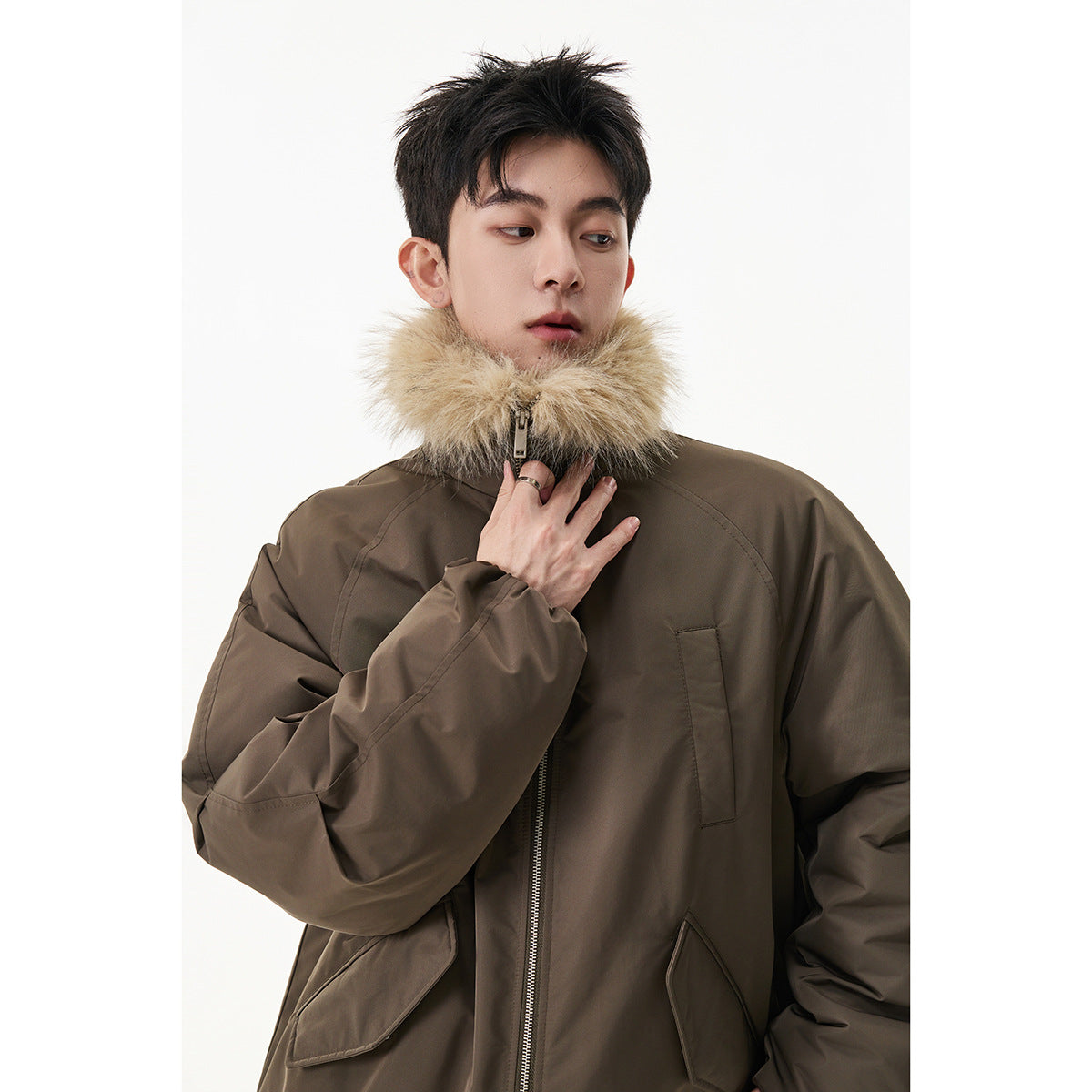 Model wearing a brown zip-front jacket with a large tan fur collar and oversized flap pockets.