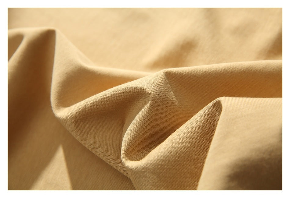 Close-up showing the tan T-shirt fabric draped into soft folds.
