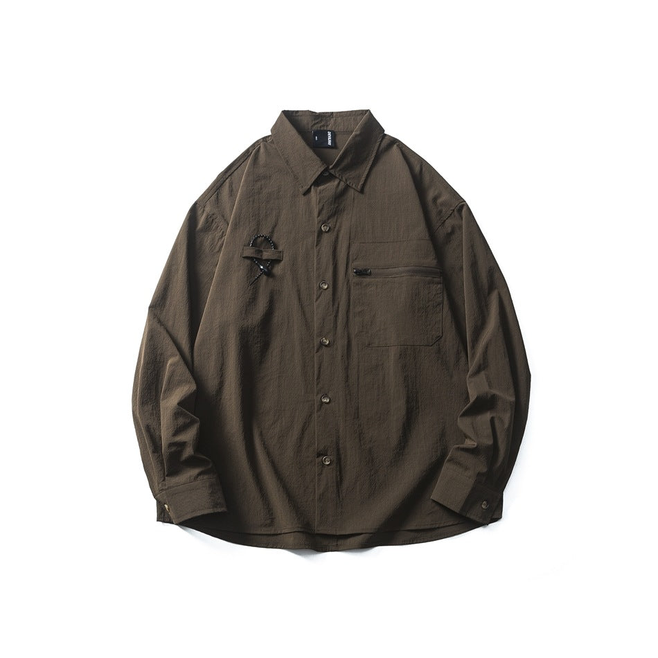 Brown long-sleeve button-up shirt with zippered chest pocket and beaded loop detail, flat lay front view