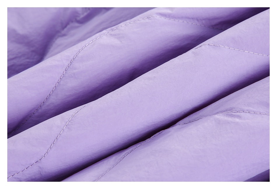 Macro view of lavender quilted fabric showing its texture and curved stitching.