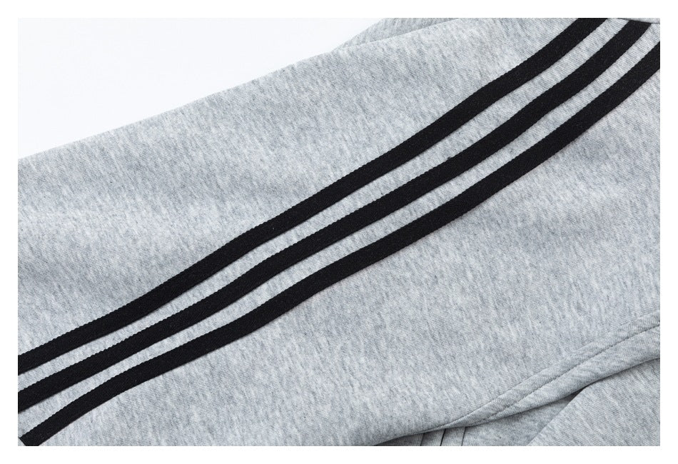 Close-up of three black stripes running along light gray heathered shorts.
