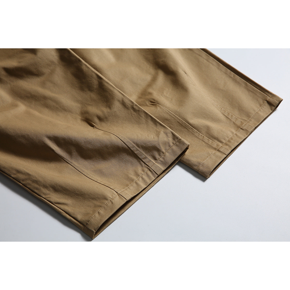 Close-up of tan trouser legs showing the straight stitched hems and seam details.
