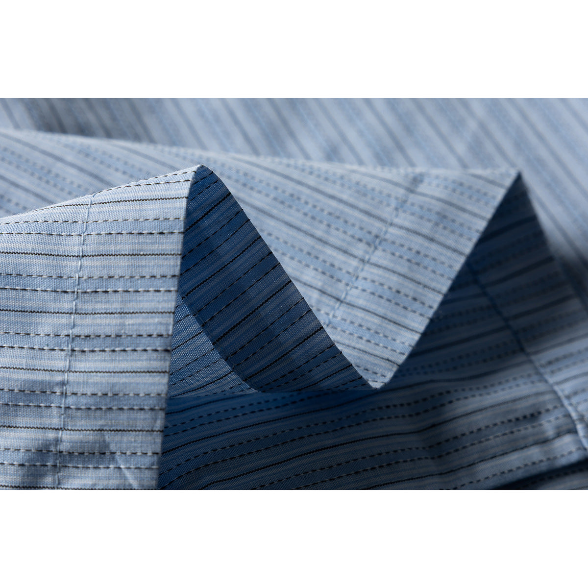 Close-up of folded collar and striped fabric on a pale blue shirt, showing stitching and seams.