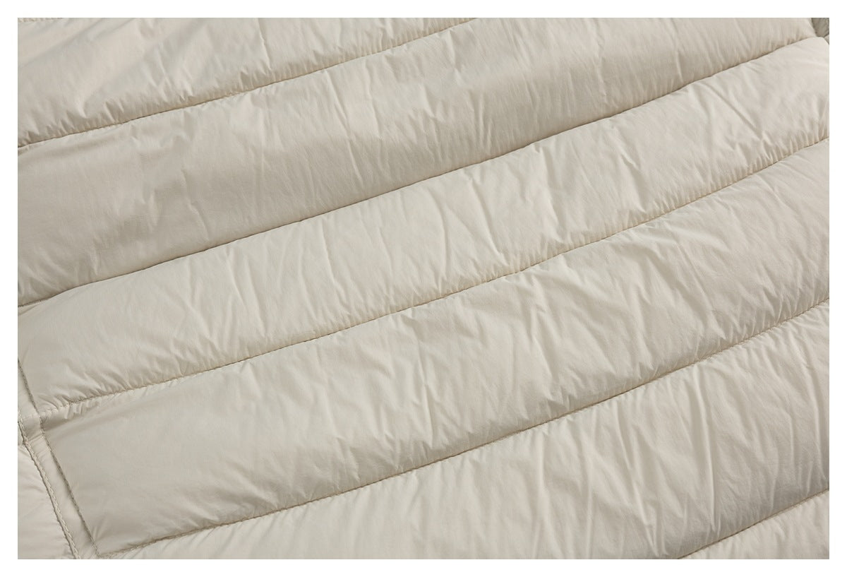 Close-up of cream padded fabric with broad parallel stitched channels and subtle wrinkles.