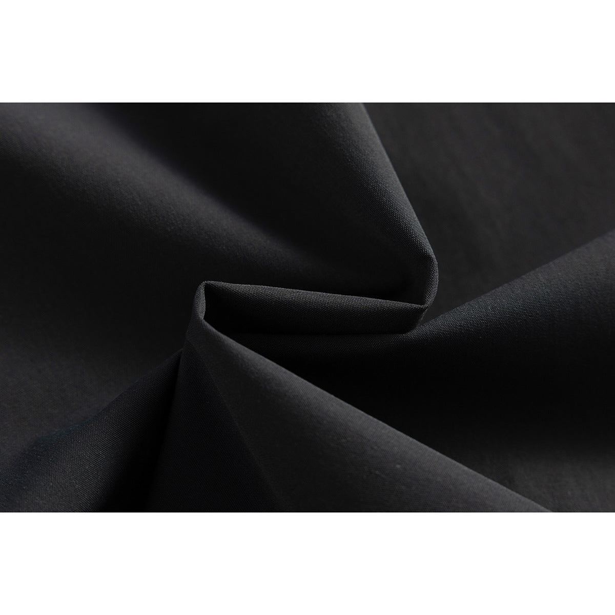 Close-up of folded black fabric showing its surface texture.