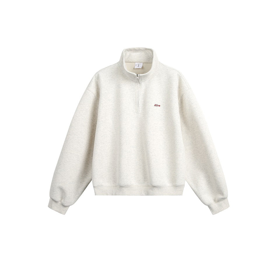 Light heather gray quarter-zip stand-collar sweatshirt flat lay with small embroidered chest text