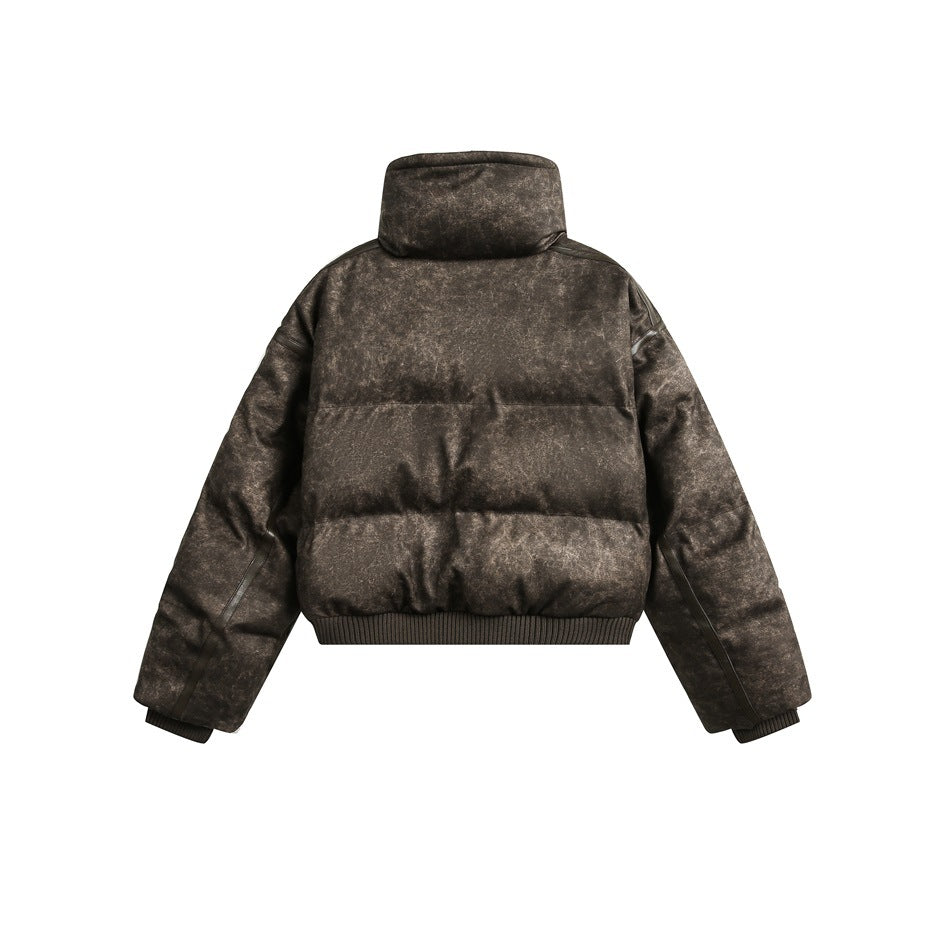 Back view of a mottled dark brown cropped puffer jacket with a high collar, quilted panels and ribbed cuffs and hem.