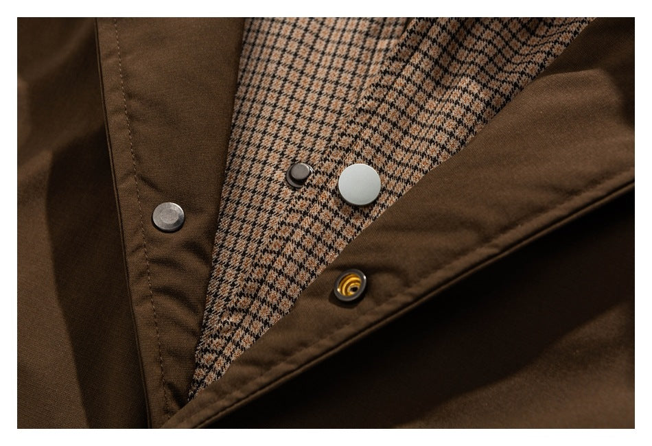 Close-up of a brown garment opening with metal snaps and a beige-and-brown checked lining.