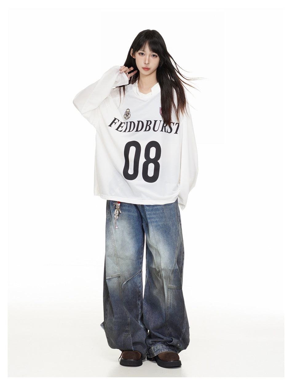 Full-length model wearing an oversized white long-sleeve jersey with black lettering and number 08, paired with wide-leg