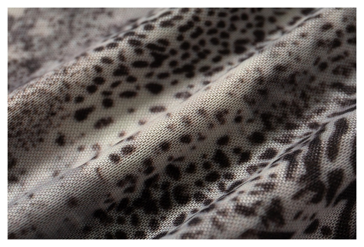 Macro view of the gray-brown animal-print fabric draped into soft folds.