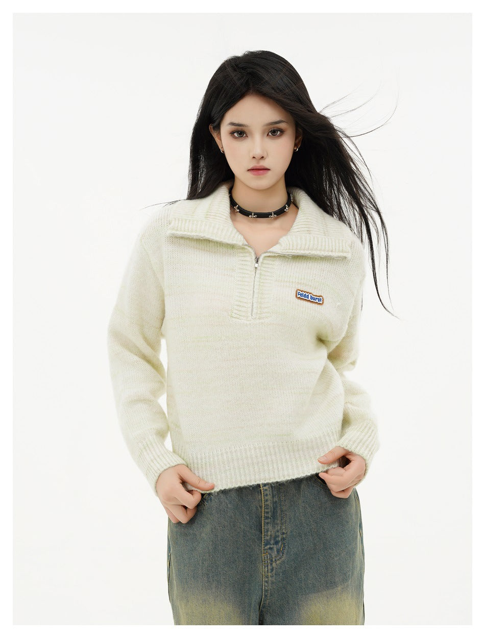 Model wearing an ivory knit quarter-zip pullover with a wide collar, ribbed cuffs, and hem.