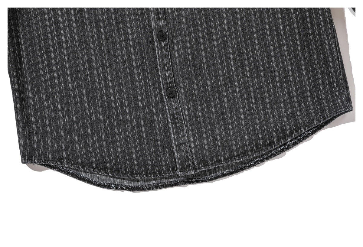 Close-up of the charcoal pinstriped shirt's curved lower hem and front buttons.