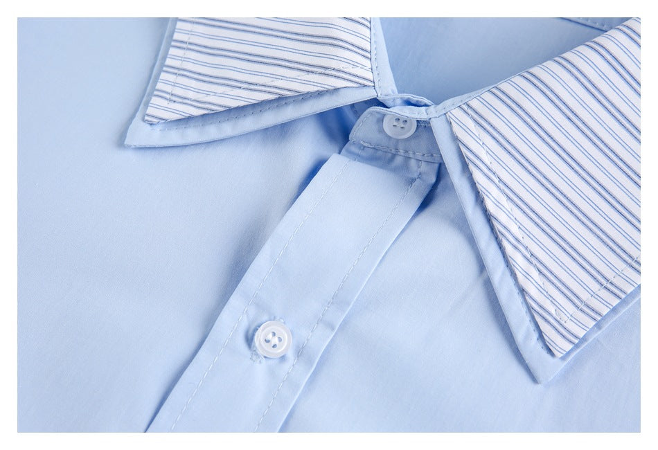 Close-up of the striped collar, button, and placket on a light blue shirt.